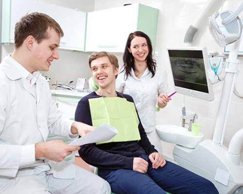 Young man speaking with dental team about treatment plan