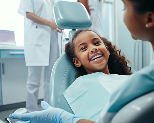 Young girl smiling while sitting in dental chair