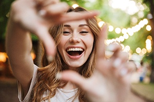 woman smiling after paying cost of cosmetic dentistry in Bedford