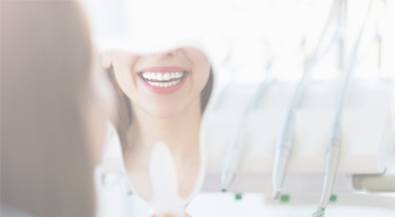 Woman looking at her smile in tooth shaped mirror