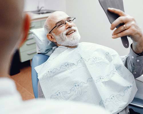 Man smiling at dentist with dentures in Bedford
