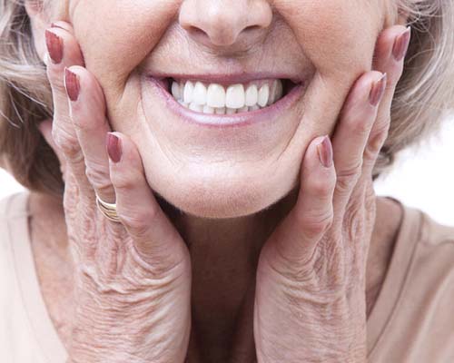 Closeup of senior woman smiling with dentures in Bedford