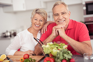 Older couple smiling and enjoying a healthy meal