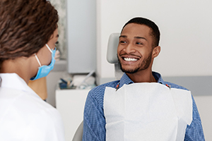 Man smiling at his emergency dentist in Bedford