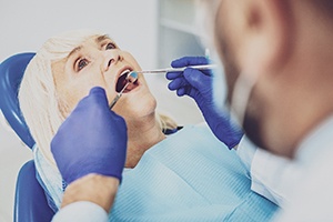 An older woman having her dental implants examined during a visit in Bedford