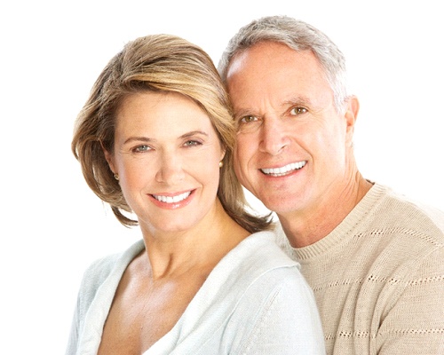 Happy senior couple enjoying benefits of implant dentures