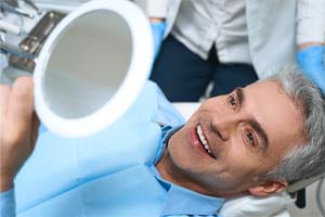 man smiling after getting dental implants in Bedford