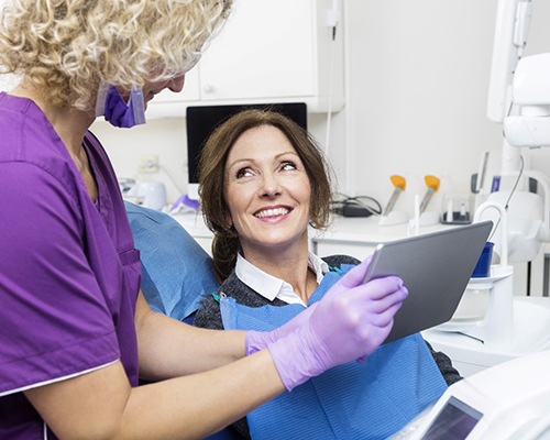 implant dentist in Bedford showing a tablet to a patient