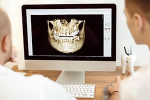 dentist looking at 3D model of a patient’s skull