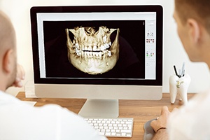 dentist looking at 3D model of a patient’s skull