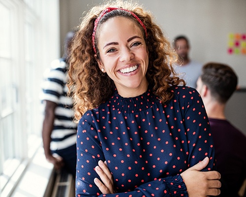 smiling person with their arms crossed