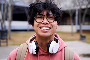 Closeup of teenage boy with black glasses smiling