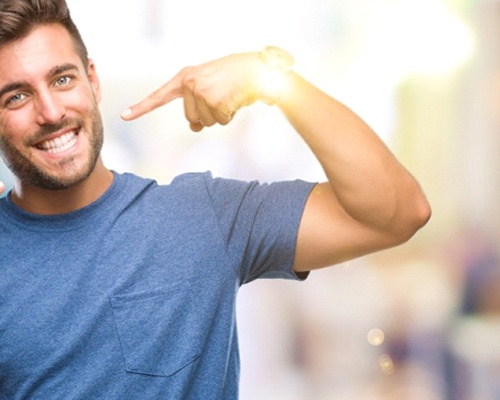 man pointing to his smile with straight white teeth