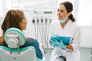 Smiling dentist taking notes on clipboard