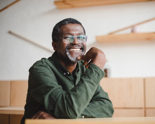 man smiling and sitting at a desk