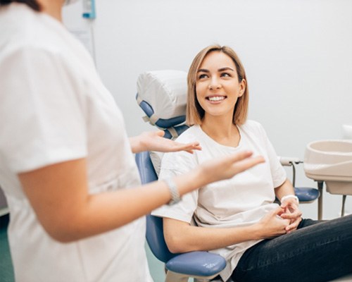 a woman smiling and talking to a dentist