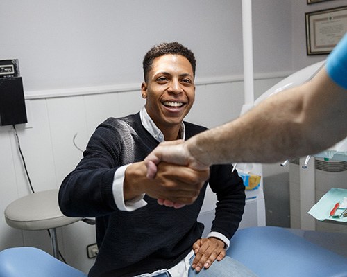Man shaking hands with dentist after full mouth reconstruction in Bedford, TX