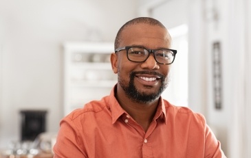 Man with flawless smile after replacing missing teeth