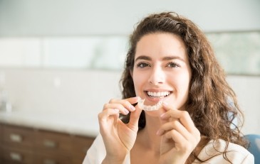 Woman placing Invisalign tray