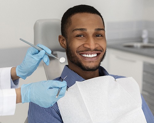 Man smiling in dental chair during his consultation