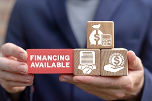 a man holding wooden blocks with financing icons on them