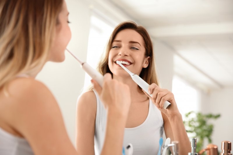 Woman brushing after wisdom tooth extraction