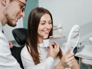 Patient looking at veneers at dentist's office. 